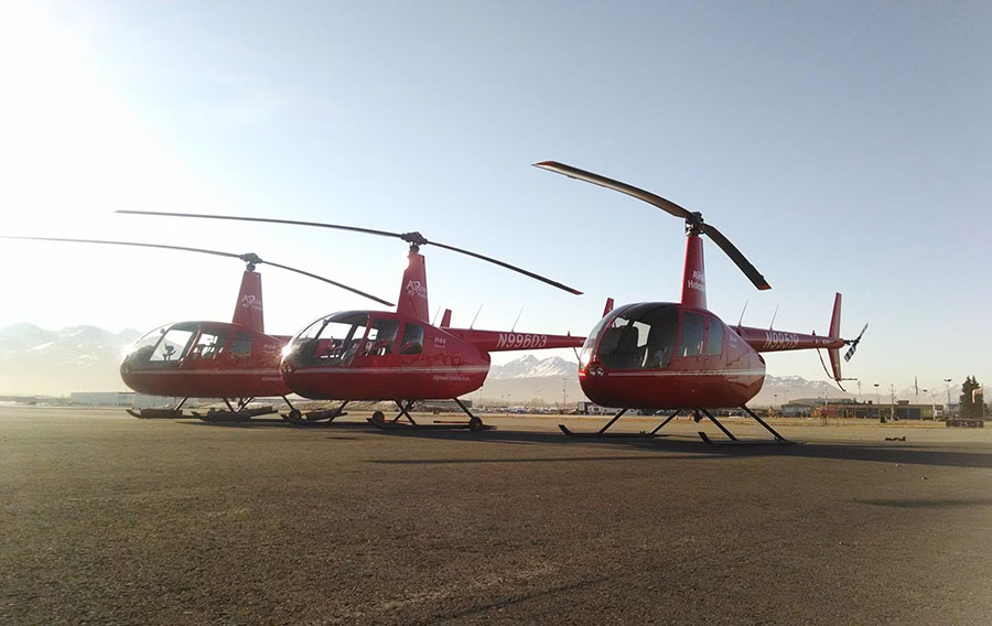 Three Robinson helicopters on the ground at the airport.