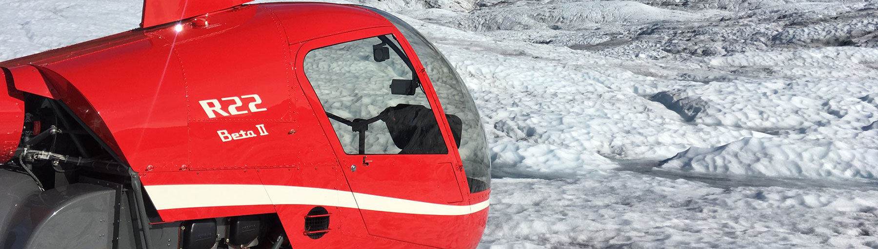 Robinson R-22 Helicopter landed next to Alaskan glacier.