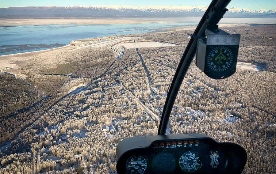 View of frosty ground out of helicopter cockpit.